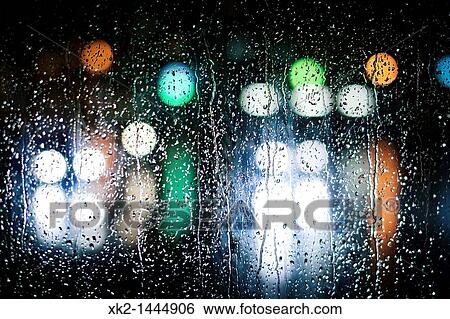 Stock Photograph - luces desenfocadas en un vidrio lleno de gotas de agua. Fotosearch