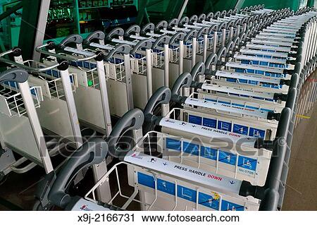 Stock Image - Luggage trolleys in an airport. Fotosearch
