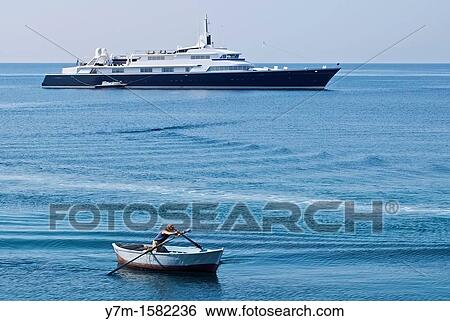 Stock Photograph - Luxury yacht and poor fisherman in contrast in the Gallipoli Bay. Fotosearch