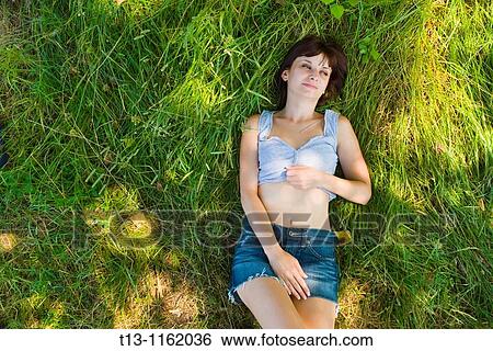 Lying on grass on her back young woman View Large Photo Image Stock Photograph - Lying on grass on her back young woman. Fotosearch