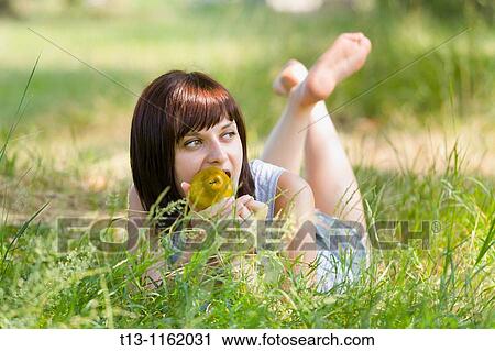 Lying on grass with a pear in her mouth View Large Photo Image Stock Image - Lying on grass with a pear in her mouth. Fotosearch