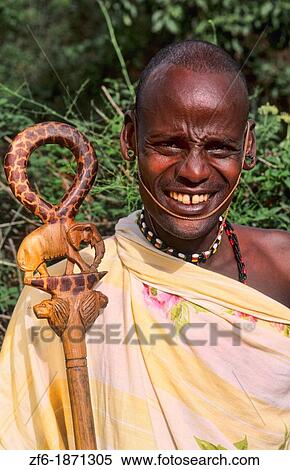 Stock Photography - Maasai tribe man with large ear hole for jewelry in costume traditional dress in jungles near Kenya Africa. Fotosearch