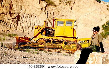 Stock Image - machinery abandoned in a quary + woman. Fotosearch