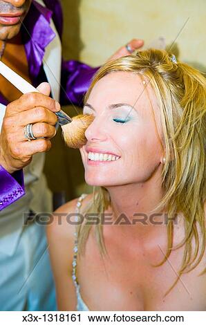 Stock Image - Make up artist applying make-up on a woman with a brush. Fotosearch