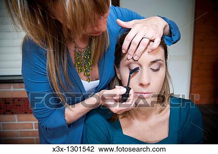 Make-up artist applying mascara on a woman model View Large Photo Image Stock Image - Make-up artist applying mascara on a woman model. Fotosearch