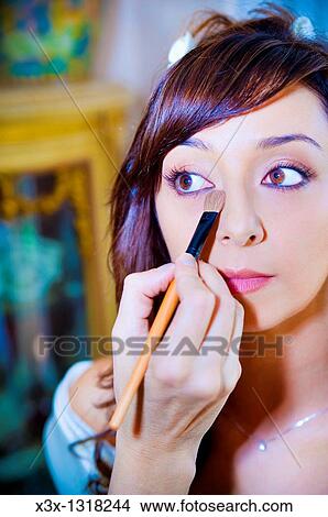 Makeup artist applying eyeshadow on a young woman with eyes open View Large Photo Image Picture - Makeup artist applying eyeshadow on a young woman with eyes open. Fotosearch