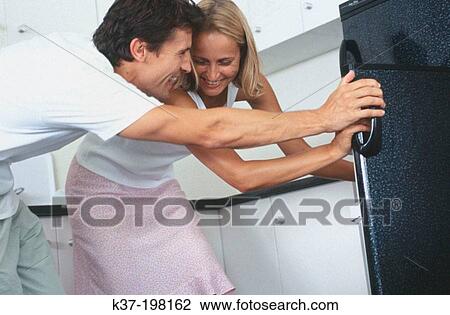 Stock Image - Making decisions for dinner & looking in fridge. Fotosearch