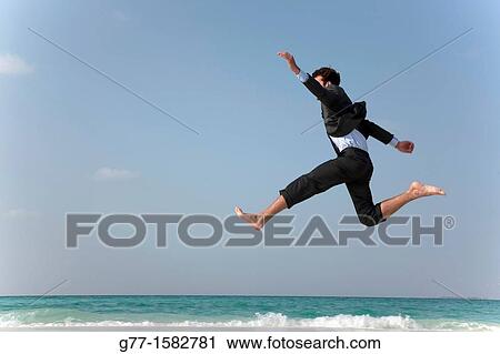 Maldives Islands Ari Atoll Business man jumping on the beach. View Large Photo Image Stock Image - Maldives Islands Ari Atoll Business man jumping on the beach.. Fotosearch
