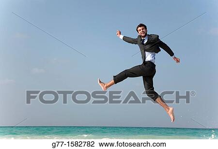 Maldives Islands Ari Atoll Business man jumping on the beach. View Large Photo Image Stock Image - Maldives Islands Ari Atoll Business man jumping on the beach.. Fotosearch