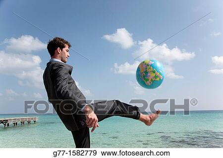 Stock Photo - Maldives Islands Ari Atoll Business man playing with world globe.. Fotosearch