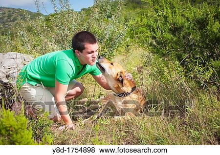 Male, 17, caucasian, playing with beige dog in natural environment near Concan, Texas, USA View Large Photo Image Stock Photo - Male, 17, caucasian, playing with beige dog in natural environment near Concan, Texas, USA. Fotosearch