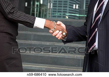 Male and female businesspeople shaking hands View Large Photo Image Stock Image - Male and female businesspeople shaking hands. Fotosearch