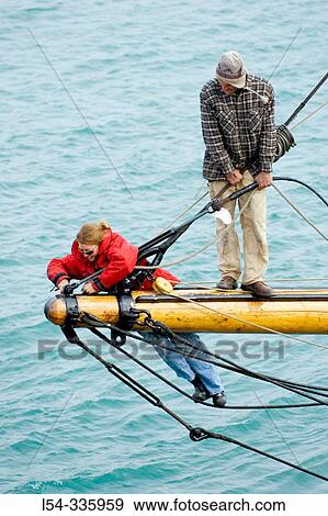 Male and female workers do maintence and repairs on the tall ship Highlander docked in the St. Clair River, Port Huron, Michigan View Large Photo Image Stock Photo - Male and female workers do maintence and repairs on the tall ship Highlander docked in the St. Clair River, Port Huron, Michigan. Fotosearch