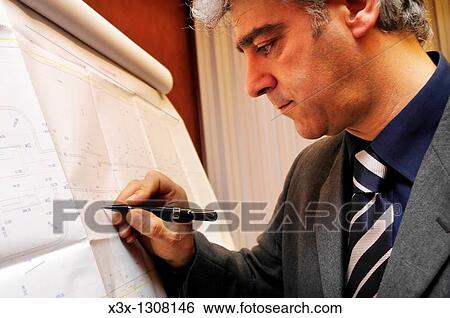 Stock Photograph - Male architect working in progress on blueprints. Fotosearch