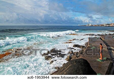 Picture - male child standing contemplating the sea waves in Bajamar municipality Tenerife island. Fotosearch