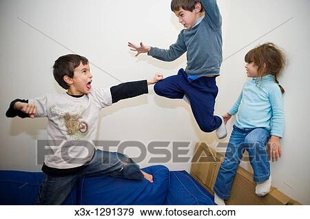Male children play fighting on the sofa View Large Photo Image Stock Photo - Male children play fighting on the sofa. Fotosearch