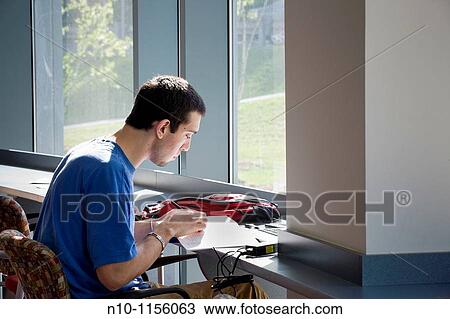 Male college student working at the student center View Large Photo Image Stock Image - Male college student working at the student center. Fotosearch
