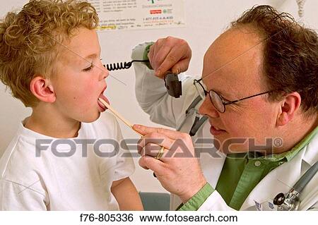 Stock Photograph - Male doctor, using a tongue depressor to examine the throat of a young boy. Fotosearch