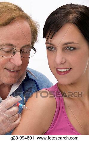 male doctor vaccinating or giving an injection to a youg woman patient View Large Photo Image Stock Image - male doctor vaccinating or giving an injection to a youg woman patient. Fotosearch