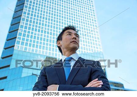 Male executive in front of skyscraper building. View Large Photo Image Stock Photograph - Male executive in front of skyscraper building.. Fotosearch