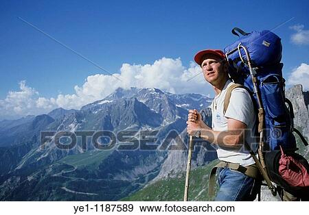 Male hiker contemplating a mountainous landscape. View Large Photo Image Stock Photo - Male hiker contemplating a mountainous landscape.. Fotosearch