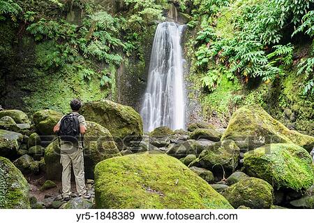 Stock Photo - Male hiker near Salto do Prego waterfall on Sao Miguel island in The Azores. Fotosearch