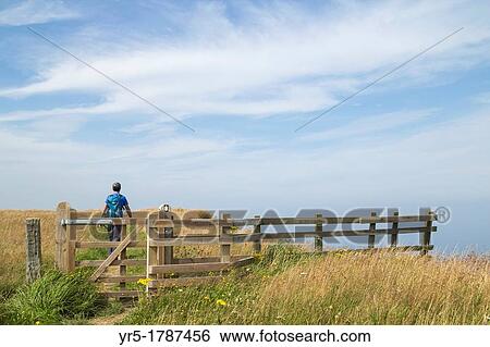 Stock Photograph - Male hiker on The Cleveland Way national trail coastal footpath near Staithes in North Yorkshire, England, United Kingdom. Fotosearch