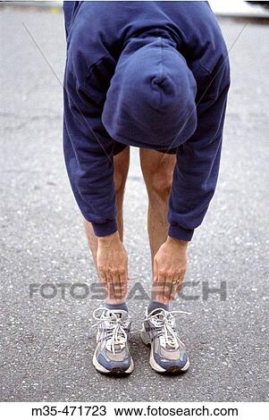 Male jogger stretching by touching his toes. View Large Photo Image Stock Image - Male jogger stretching by touching his toes.. Fotosearch