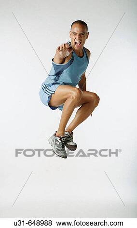 Stock Photo - Male Latin athlete jumps in the studio. Fotosearch