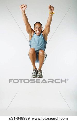Stock Photo - Male Latin athlete jumps in the studio. Fotosearch