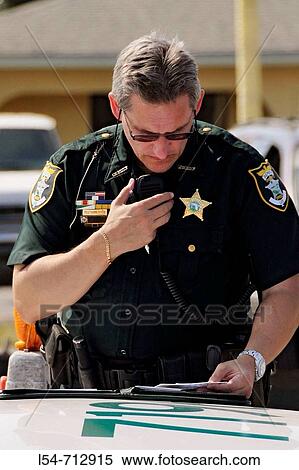 Male police officer using microphone to communicate on the scene of an accident View Large Photo Image Stock Photography - Male police officer using microphone to communicate on the scene of an accident. Fotosearch