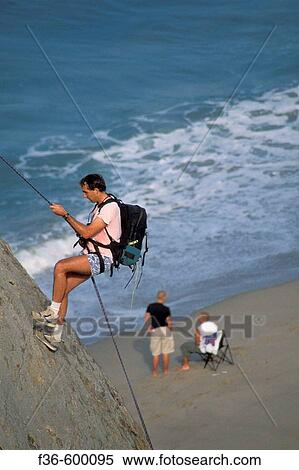 Male rock climber rappelling down cliff after climb at Point Dume State Beach near Malibu, Los Angeles County, California View Large Photo Image Stock Photography - Male rock climber rappelling down cliff after climb at Point Dume State Beach near Malibu, Los Angeles County, California. Fotosearch