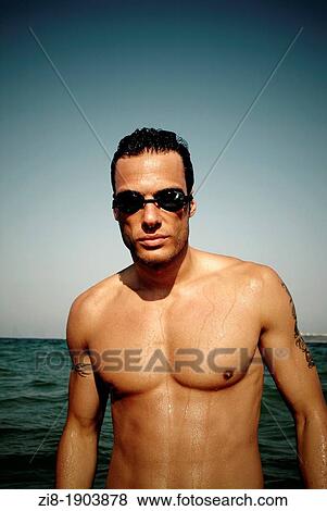 Stock Photo - Male swimmer on the beach. Fotosearch