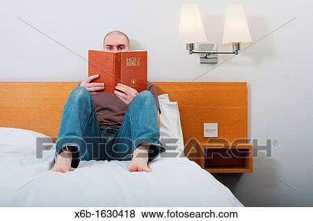 Man, 30-40 years, reading Holy Bible in a hotel room View Large Photo Image Stock Photo - Man, 30-40 years, reading Holy Bible in a hotel room. Fotosearch