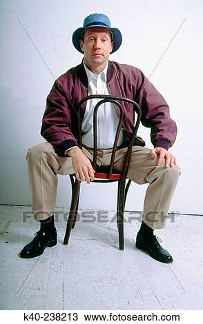 Man, 40-45, looking at camera while sitting on chair View Large Photo Image Stock Image - Man, 40-45, looking at camera while sitting on chair. Fotosearch