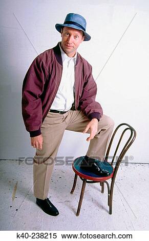 Man, 40-45, smiling at camera with foot on chair View Large Photo Image Stock Photography - Man, 40-45, smiling at camera with foot on chair. Fotosearch