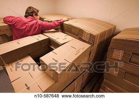 Man adjusting stacks of new and unfolded cardboard boxes. View Large Photo Image Stock Photo - Man adjusting stacks of new and unfolded cardboard boxes.. Fotosearch