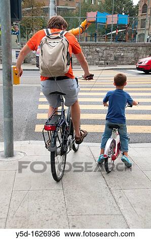 man and boy on bicycles, waiting for green light to cross the street, Geneva, Switzerland View Large Photo Image Stock Photograph - man and boy on bicycles, waiting for green light to cross the street, Geneva, Switzerland. Fotosearch