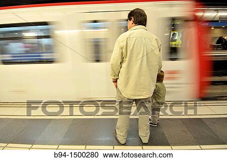 Stock Image - Man and child in subway station, Barcelona, Catalonia, Spain. Fotosearch