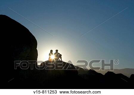 Man and woman sitting on rocks in sunset - elefant rocks View Large Photo Image Stock Image - Man and woman sitting on rocks in sunset - elefant rocks. Fotosearch