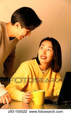 Stock Image - Man and woman using laptop. Fotosearch