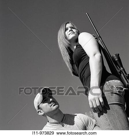 Stock Photo - Man and woman with rifle; rural.. Fotosearch