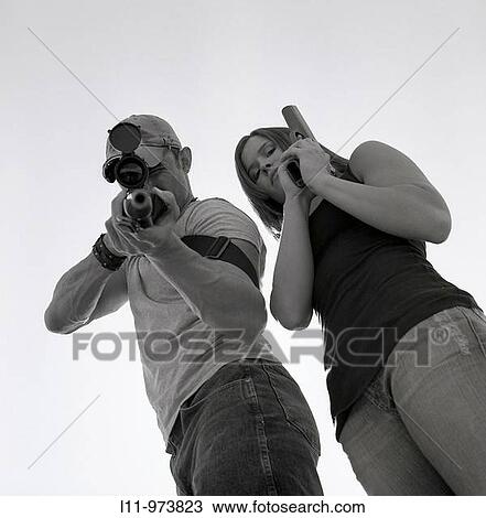 Man and women with guns; aiming at lens. View Large Photo Image Stock Image - Man and women with guns; aiming at lens.. Fotosearch
