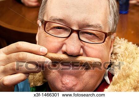 Man at his 70th birthday smelling but not smoking a Cuban cigar St Paul Minnesota MN USA View Large Photo Image Stock Image - Man at his 70th birthday smelling but not smoking a Cuban cigar St Paul Minnesota MN USA. Fotosearch
