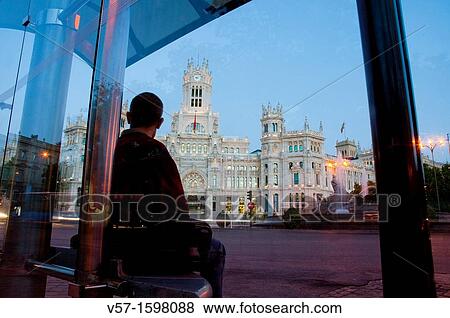 Man at the bus stop, night view. Cibeles Square, Madrid, Spain. View Large Photo Image Stock Photo - Man at the bus stop, night view. Cibeles Square, Madrid, Spain.. Fotosearch