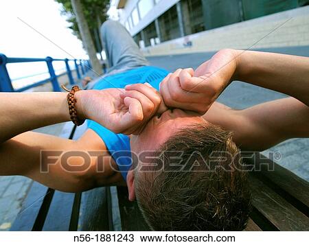 Stock Image - Man awakening on a bench. Fotosearch