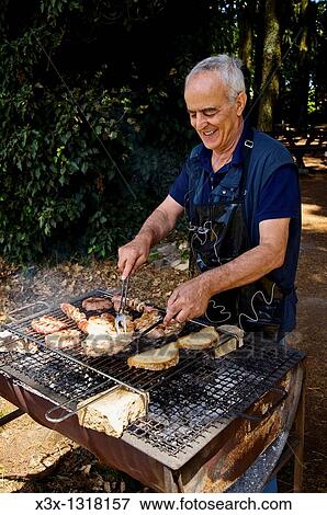 Man barbecuing in a park View Large Photo Image Stock Photo - Man barbecuing in a park. Fotosearch