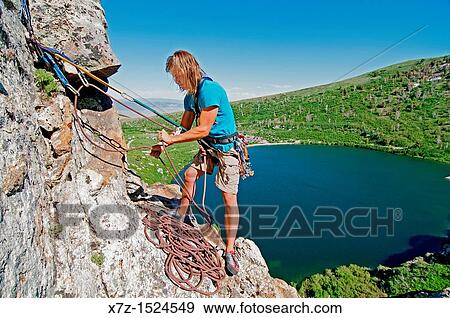 Man belaying while rock climbing a route called Angel Toes which is rated 5, 10 and located on The Angel Lake Crag above Angel Lake high in the East Humboldt Mountains of northern Nevada View Large Photo Image Stock Photo - Man belaying while rock climbing a route called Angel Toes which is rated 5, 10 and located on The Angel Lake Crag above Angel Lake high in the East Humboldt Mountains of northern Nevada. Fotosearch