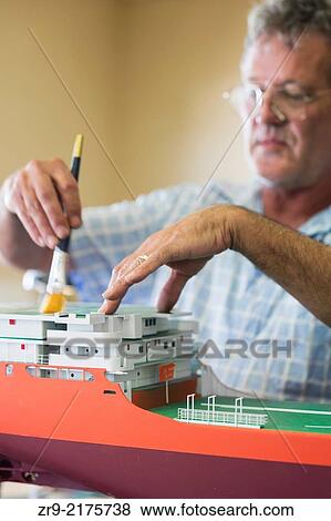 Man brushes dust from a model of the DeBeers Diamond Mining ship operating off the coast of Namibia, Model Ship Builder, ShipYard, Mosselbay, South Africa. View Large Photo Image Stock Photo - Man brushes dust from a model of the DeBeers Diamond Mining ship operating off the coast of Namibia, Model Ship Builder, ShipYard, Mosselbay, South Africa.. Fotosearch