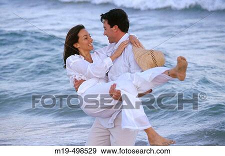man carrying a woman in his arms View Large Photo Image Stock Photo - man carrying a woman in his arms. Fotosearch